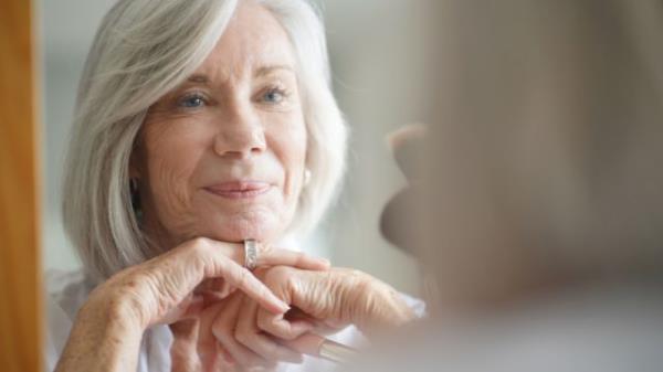 older white woman looking in mirror