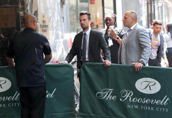 Detectives are seen outside the Roosevelt Hotel, after a migrant allegedly attacked a worker. 