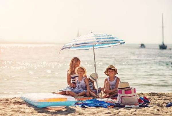 Mother wit hkids havin<em></em>g fun on the beach. Sunny summer day. Mallorca, Spain.