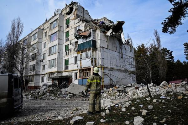 A rescue worker looks at a damaged building