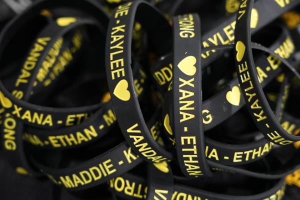 Bracelets with the names of the four University of Idaho students who were killed on Nov. 13, 2022, are displayed on a table at a vigil for the victims, Wednesday, Nov. 30, 2022, in Moscow, Idaho. (AP Photo/Ted S. Warren)