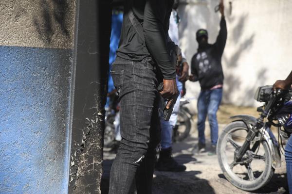 Armed police officers stands with weapons drawn in front of the police headquarters during a protest to denounce bad police governance, in Port-au-Prince, Haiti, Thursday, Jan. 26, 2023.