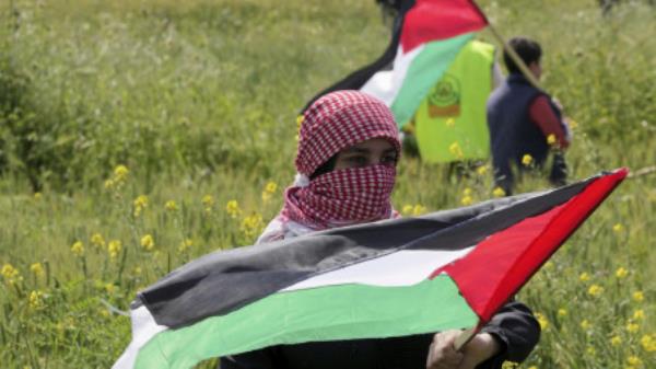 Palestinians wave flags during a rally marking the 47th anniversary of Land Day, along the border fence with Israel, east of Gaza City, Thursday, March 30, 2023. An Israeli human rights group says that Israel is holding over 1,000 Palestinian detainees without charge or trial, the highest number since 2003. HaMoked, an Israeli rights group that regularly gathers figures from prison authorities, said Tuesday, April 4, that as of April 2023 there were 1,016 detainees held in administrative detention. (AP Photo/Adel Hana)