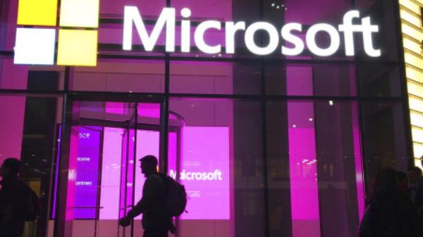 FILE - People walk past a Microsoft office in New York, Nov. 10, 2016. On Tuesday, Jan. 24, 2023, Microsoft reported a 12% drop in profit for the October-December 2022 quarter, reflecting the eco<em></em>nomic uncertainty it said led to its decision to cut 10,000 workers. (AP Photo/Swayne B. Hall, File)