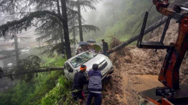 People pull a vehicle to a safer place after a landslide following heavy rainfall, in Shimla, Sunday. Photo: PTI/HT