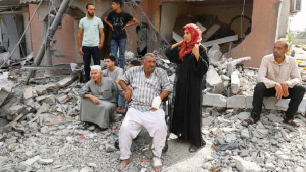 Palestinians watch the civil defense team as they search for victims trapped under the rubble of a house destroyed during Israeli strikes, in Khan Younis, in the southern Gaza Strip, October 8, 2023. REUTERS/Ibraheem Abu Mustafa