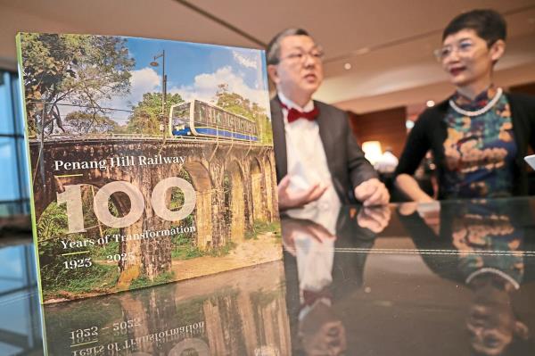 Loh (left) and Lee posing with the book 'Penang Hill Railway: 100 Years Of Transformation' during its launch in George Town last month. Photo: The Star/Chan Boon Kai