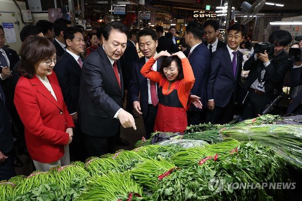 President Yoon Suk Yeol (2nd from L) purchases water parsley at Chilseong Market in the southeastern city of Daegu on Nov. 7, 2023. (Yonhap)