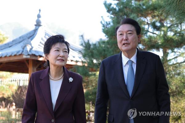President Yoon Suk Yeol (R) and former President Park Geun-hye co<em></em>nverse while taking a walk outside Park's home in the southeastern city of Daegu on Nov. 7, 2023, in this photo provided by the presidential office. (PHOTO NOT FOR SALE) (Yonhap)