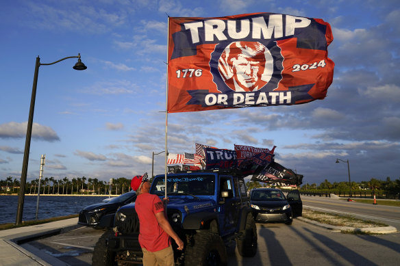 A supporter of Do<em></em>nald Trump raises a flag outside the former president’s Mar-a-Lago estate in Florida on Monday.