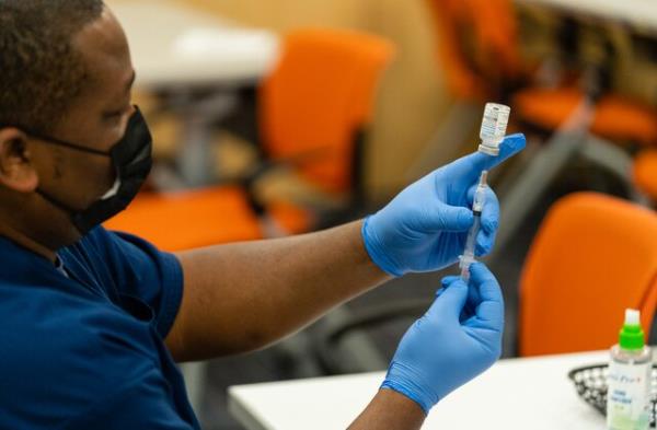 SILVER SPRING, MARYLAND - NOVEMBER 21: A healthcare employee prepares a syringe with the Moderna COVID-19 vaccine at the Dennis Avenue Health Center in Silver Spring, Maryland on November 21, 2022. While COVID-19 remains a serious co<em></em>ncern for this holiday season, this year two other common respiratory viruses, influenza and RSV, are wreaking havoc  particularly in the D.C. area, which is one of the regions with the highest flu activity in the country. (Eric Lee for The Washington Post via Getty Images)