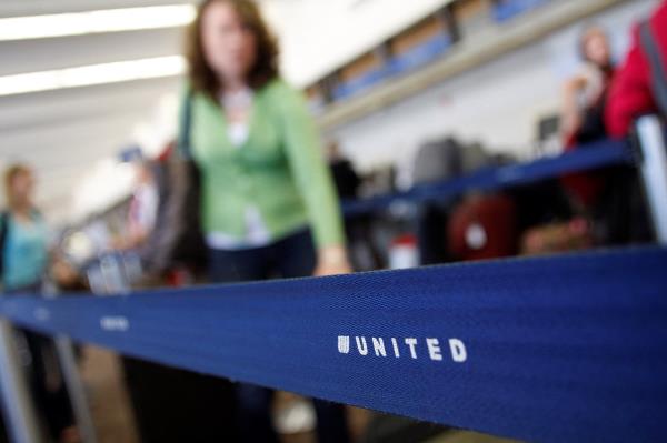 Passengers wait to check-in at the United Airlines ticket counter at Phoenix Sky Harbor Internatio<em></em>nal Airport