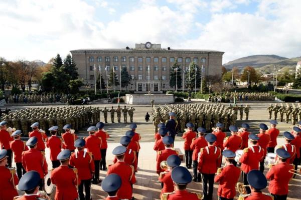 Soldiers from Azerbaijan on parade in Nagorno-Karabakh region's capital city. There is a miitary band in red ceremo<em></em>nial uniforms.