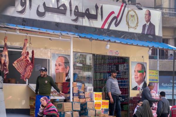 Clients buy groceries at a government spo<em></em>nsored shop fro<em></em>nted with Egyptian President Abdel Fattah el-Sissi posters in Cairo, Egypt, Feb 27, 2023