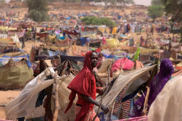 A Sudanese girl who fled the co<em></em>nflict in Sudan's Darfur region, and was previously internally displaced in Sudan, moves past makeshift shelters, near the border between Sudan and Chad