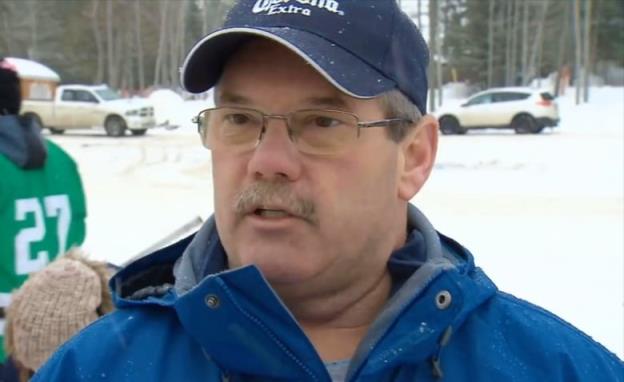 A man standing outside in a blue jacket and Corona ba<em></em>seball hat.