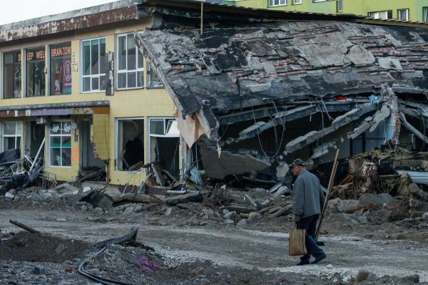 A man with a broom walks by a destroyed building days after intensive flooding in Stro<em></em>nie Slaskie, Poland, September 20, 2024.