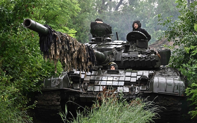 Ukrainian servicemen check their T-72 tank at a position in the Do<em></em>netsk region 