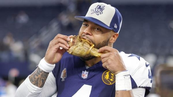 Cowboys quarterback Dak Prescott celebrates with a turkey leg
