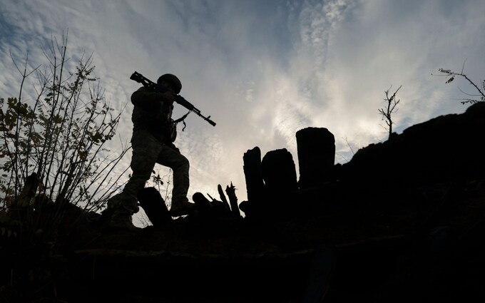 A Ukrainian serviceman of the 65th separate mechanized brigade inspects the former position of Russian troops
