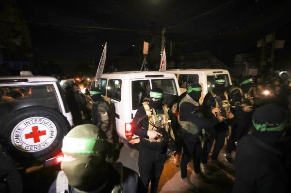 Hamas fighters accompany newly released hostages before handing them over to the Red Cross, in Rafah the southern Gaza Strip on Tuesday, November 28, 2023.