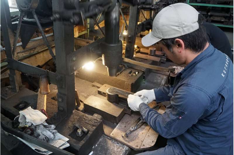 Yoshihiro Yauji places a 'santoku', a multipurpose knife, under a spring hammer, co<em></em>ntinuing a tradition dating back centuries