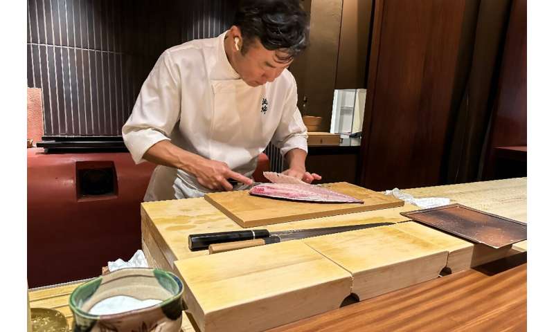 Chef Shintaro Matsuo expertly slices through a piece of yellowtail with a knife made in the nearby city of Sakai, at his restaurant in Osaka
