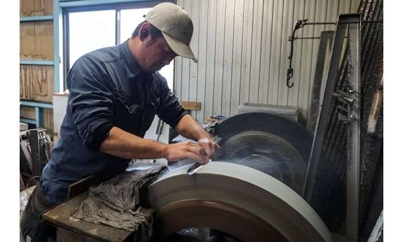 Yoshihiro Yauji sharpens a freshly forged 'santoku', a multipurpose knife, at the Takefu Knife Village in Fukui prefecture