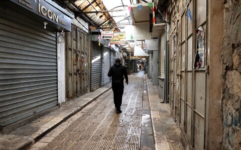 A Palestinian man walks along an empty street during a general strike in the West Bank city of Nablus, 11 December 2023.