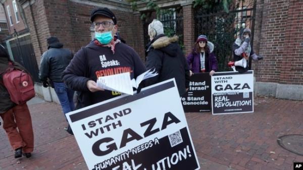 George Stevens of Cambridge, Mass., hands out leaflets to passers-by near an entrance to Harvard University, Dec. 12, 2023, in Cambridge, while joining with pro-Palestinian demo<em></em>nstrators during a protest held to call for an end to the war in Gaza.