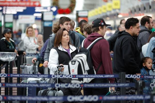 Travelers check-in for their flights at Chicago O'Hare Internatio<em></em>nal Airport wher<em></em>e there was reported o<em></em>nly 15 canceled flights with minimal delays. 