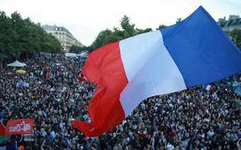 People, holding flags and banners, gather at the Republique Square following the second round results of France's legislative election in Paris