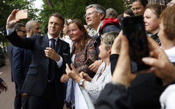 French President Emmanuel Macron makes a selfie for supporters after voting for the second round