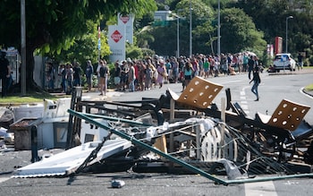 People queue at a supermarket to stock up on essentials after rioting in Noumea