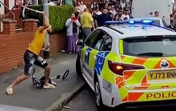 A police car being attacked before it was overturned