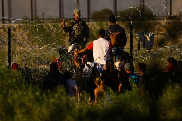 A member of the Texas Natio<em></em>nal Guard stands guard with the purpose of inhibiting the crossing of migrants to the United States.