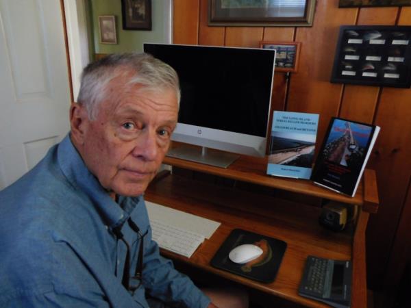 Robert Banfelder at a desk with two books he has writen