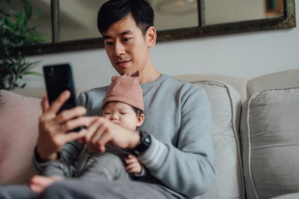 Father working at home while taking care of his baby