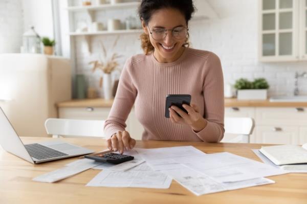 Woman smiles as she checks her finances