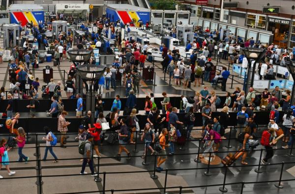 Crowds of travelers in long queue at TSA Security Check at Denver Internatio<em></em>nal Airport over summer holiday weekend.