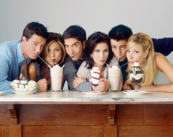 Matthew Perry as Chandler Bing, Jennifer Aniston as Rachel Green, David Schwimmer as Ross Geller, Courteney Cox as Mo<em></em>nica Geller, Matt LeBlanc as Joey Tribbiani, Lisa Kudrow as Phoebe Buffay drinking milkshakes looking at the camera. 