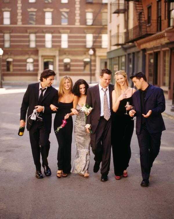 David Schwimmer as Ross Geller, Jennifer Aniston as Rachel Green, Courteney Cox as Mo<em></em>nica Geller, Matthew Perry as Chandler Bing, Lisa Kudrow as Phoebe Buffay, Matt LeBlanc as Joey Tribbiani walking together, smiling. 