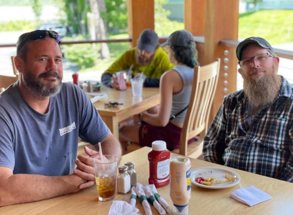 Jason Walker, left, and friend Michael Deslauriers II, right, pose at a restaurant.