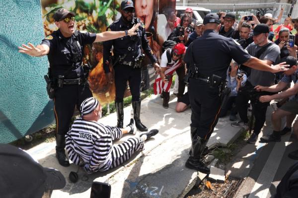 A protester sits on the ground after being cuffed