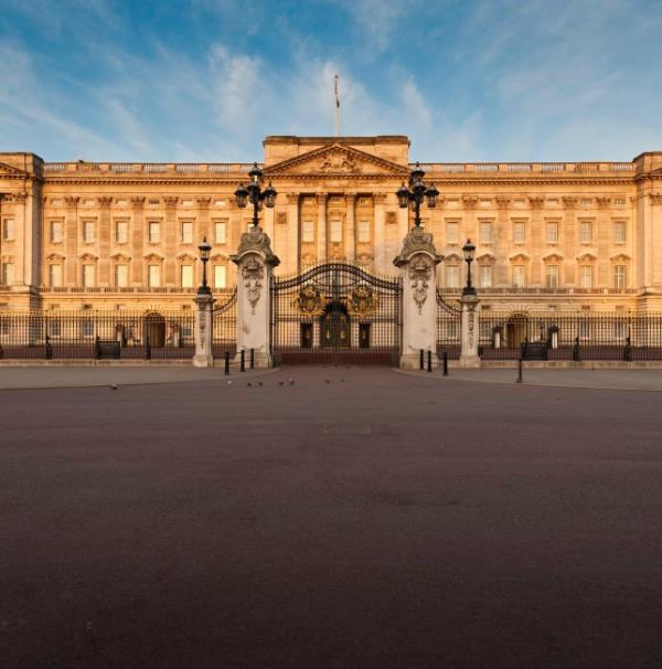 London, UK - May 3th, 2011: Warm dawn sunlight illuminated the Portland stone facade, windows, balcony and ornate entrance gates of Buckingham Palace, Lo<em></em>ndon residence of the British Monarch, from the Victoria Memorial on The Mall.