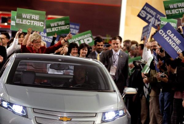 Michigan Gov. Jennifer Granholm (red dress) marches with auto workers and dignitaries behind a Chevy Volt electric vehicle during the introduction of General Motors' vehicles during the press preview for the Detroit Internatio<em></em>nal Auto Show at the Cobo Center January 11, 2009 in Detroit, Michigan