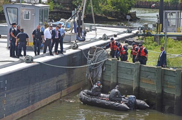 NYPD officers are pictured retrieving a body from the water in the Newtown Creek near the Metropolitan Avenue bridge. 