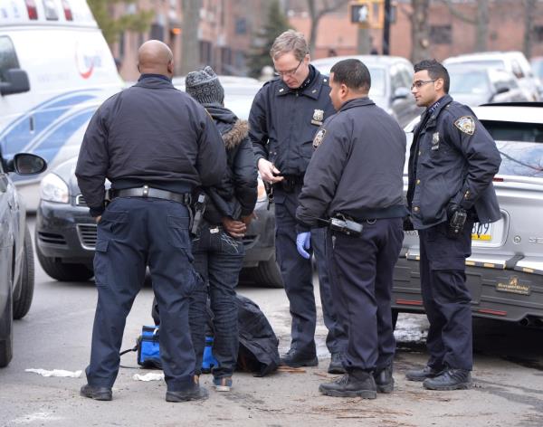 A woman being arrested by a group of police officers on a Brooklyn street for shoplifting Tide detergent from a CVS Pharmacy.