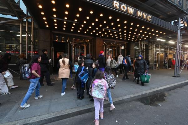 Group of migrants outside Row NYC hotel on 8th Ave., New York wher<em></em>e migrants reside