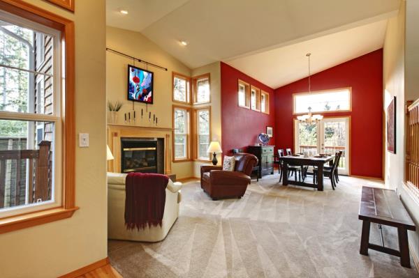 Modern large open living room with a red wall and a fireplace